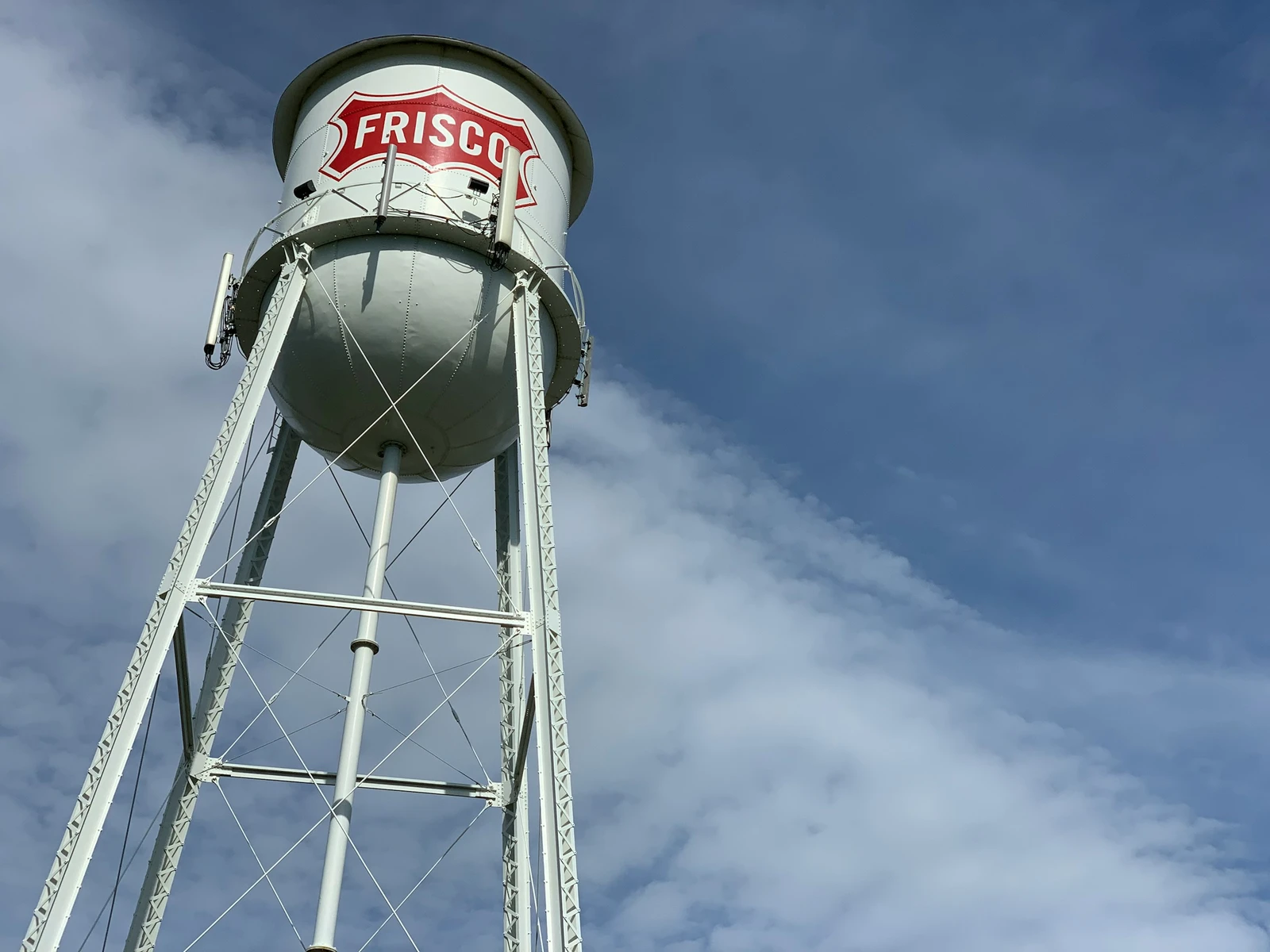 The historic Frisco water tower with its red Frisco shield against a blue Texas sky